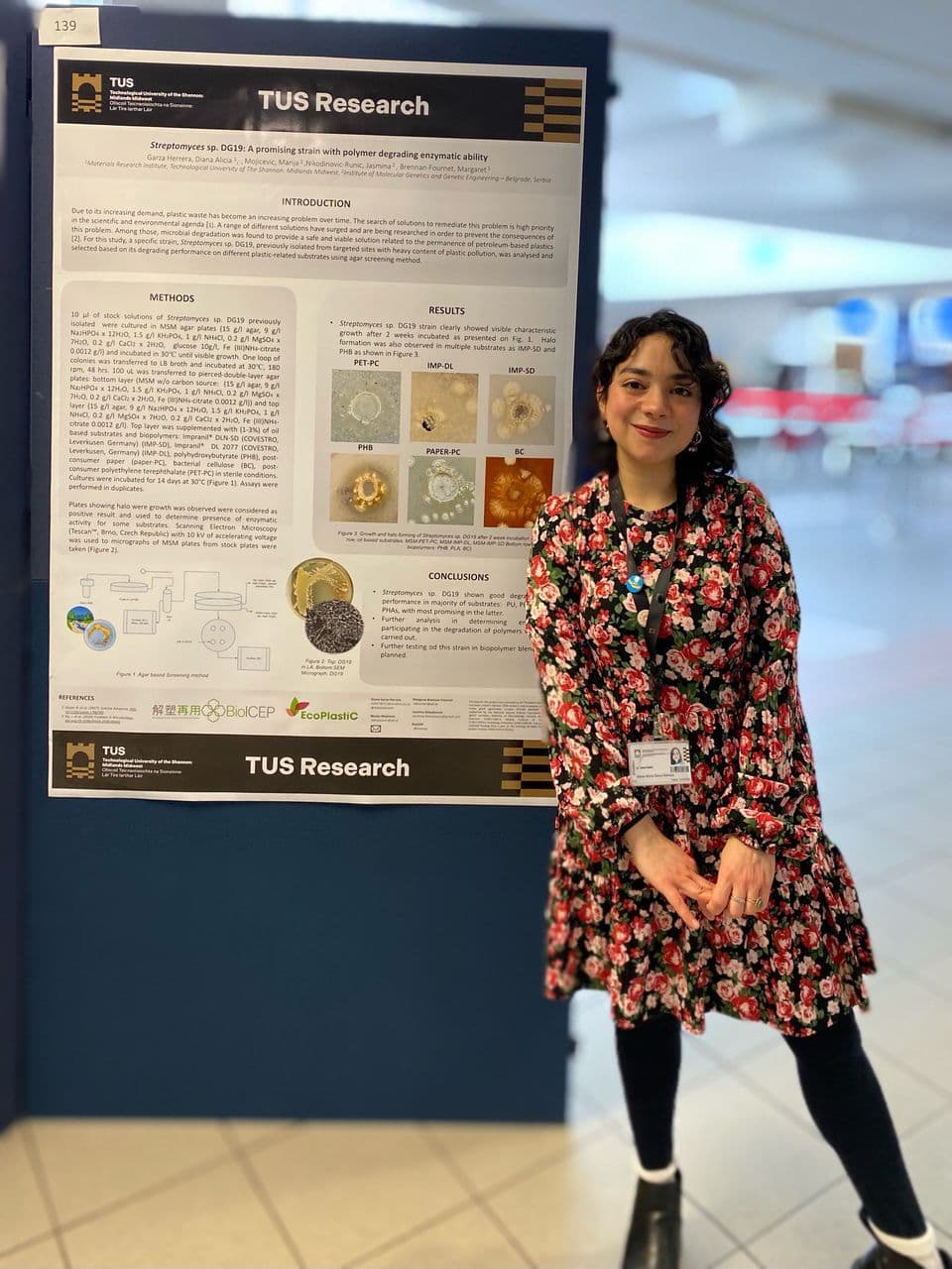 Diana Garza standing next to her poster presentation